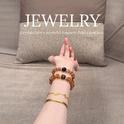 The multi-treasure bracelet is displayed flat, a perfect combination of yellow crystal for attracting wealth and strawberry crystal for attracting love