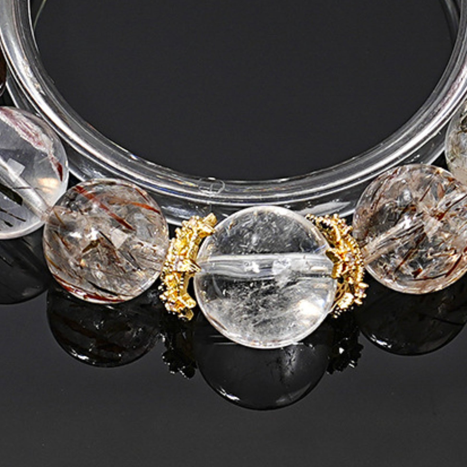 The details of the black gold Super Seven mineral inclusions are displayed with a brilliant luster against the backdrop of white crystal