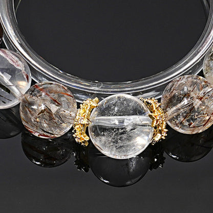 The details of the black gold Super Seven mineral inclusions are displayed with a brilliant luster against the backdrop of white crystal