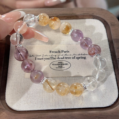 A close-up of natural Bolivian amethyst, showcasing its deep purple color and mood-stabilizing effect, strung with white crystal and yellow tower crystal.