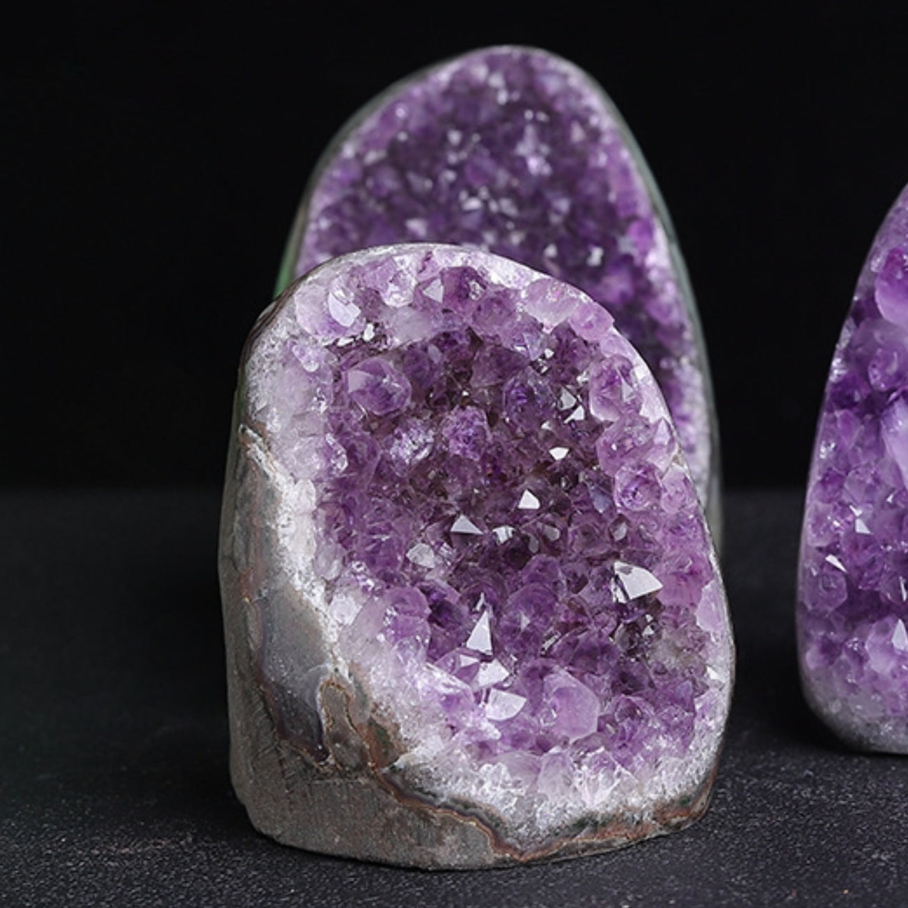 Place the crystal bracelet on top of the amethyst cluster to demonstrate its practical application as a natural energy charging station for purifying and charging other crystals.