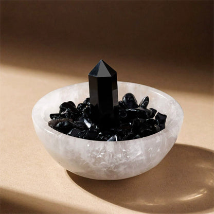 Hand placing a necklace onto the Selenite stones inside the bowl for energetic cleansing.