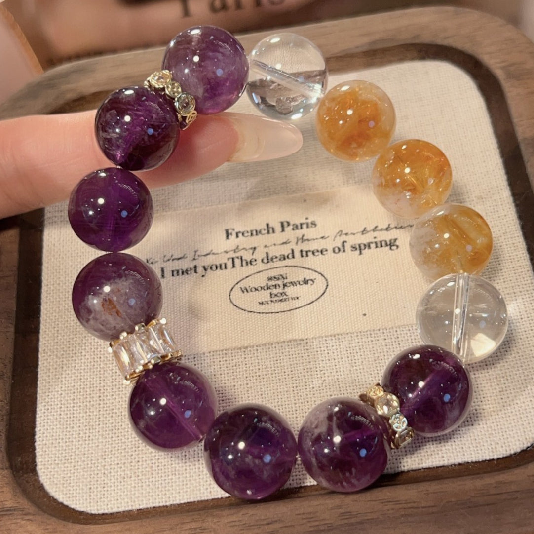 A close-up of a girl wearing a woven bracelet made of natural amethyst and yellow tower crystal showcases the blend of light luxury design and energy crystal, which is used for attracting wealth and enhancing intuition.