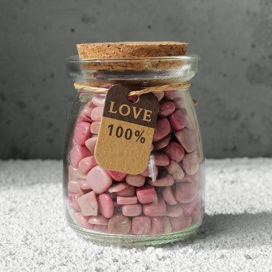 The "Star Wish Cabin" crystal intention bottle was held in the sunlight by a pair of hands, and the pink, purple and white crystals inside the bottle refracted brilliant light.