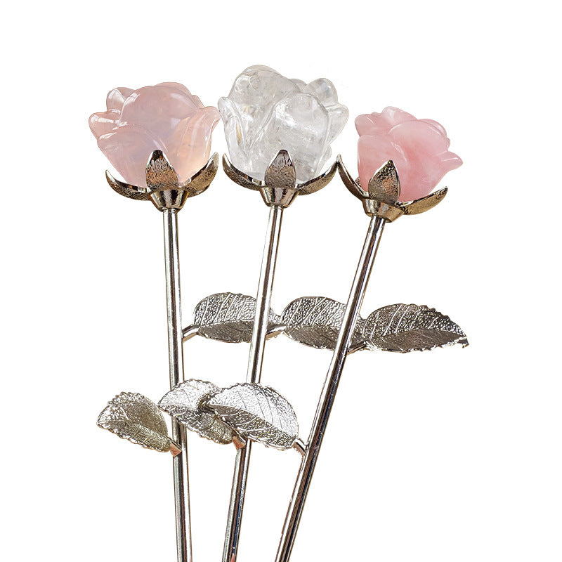 A crystal rose is placed on a simple dressing table, with scented candles and jewelry beside it, symbolizing a self-love ritual.