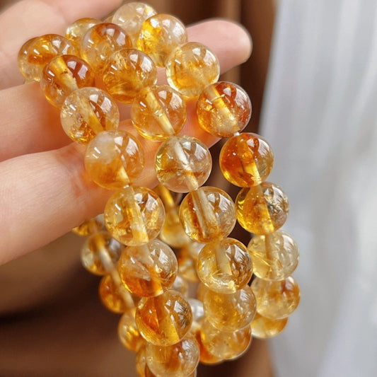 Close-up of a 10mm yellow crystal, yellow tiger's eye and yellow Asai stone bracelet, showing how these three golden crystals work together to activate the solar plexus chakra