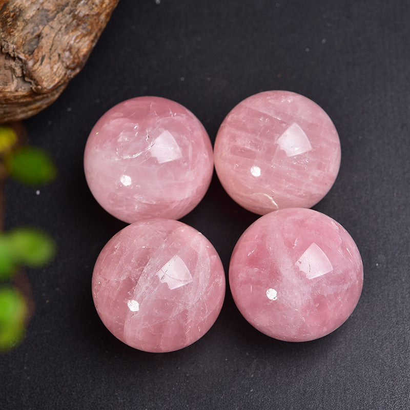 The user holds a pink crystal ball for meditation or energy work