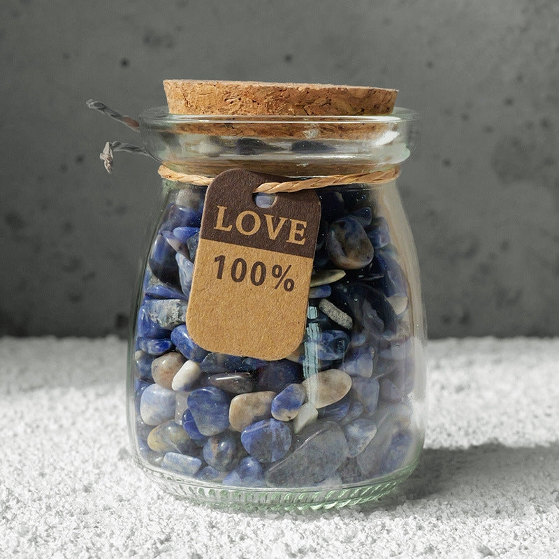 Dynamic snapshot: A hand is putting a new wish note into a crystal bottle that is already half full.