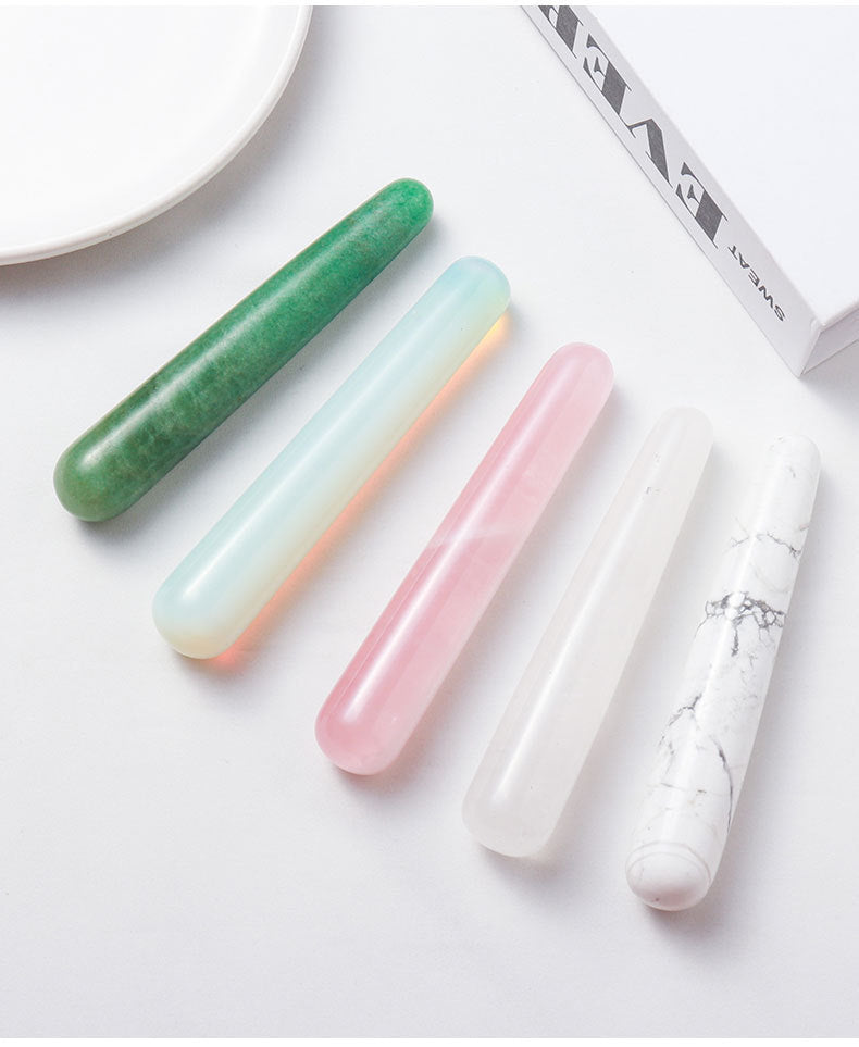 Close-up of the exquisitely cut surface of the massage stick, showcasing the natural misty texture and warm luster of the rose quartz