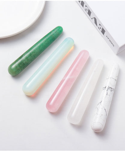 Close-up of the exquisitely cut surface of the massage stick, showcasing the natural misty texture and warm luster of the rose quartz