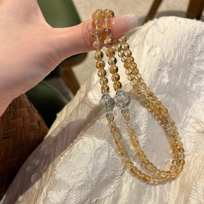 The three-circle entwined design of Brazilian yellow quartz, yellow ace stone and green ghost showcases a progressive energy field for attracting wealth