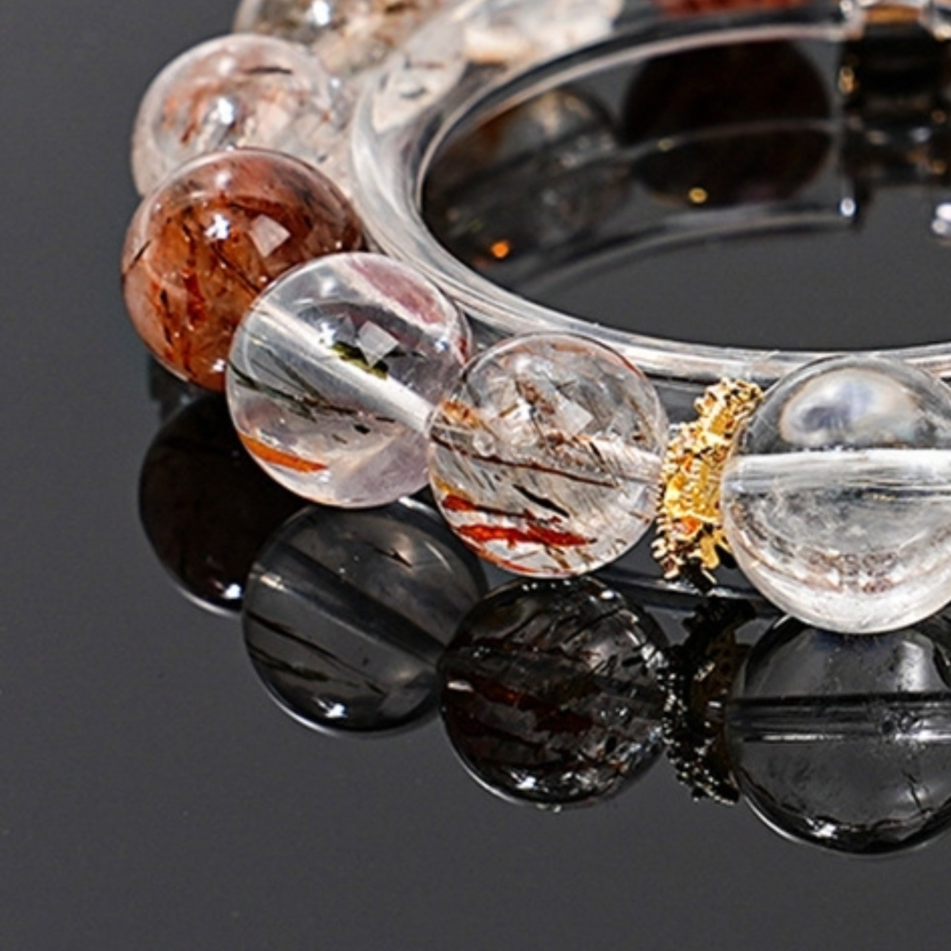 A close-up of the bracelet worn on the wrist, with the black and white contrast naturally brightening the skin tone