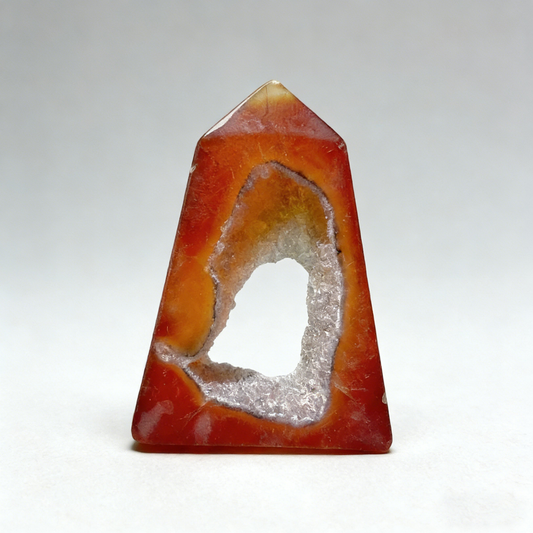 Front view of a Natural Red Agate Geode Square Tower, showing hexagonal point and crystal cave on square base.