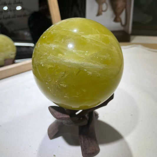 Polished yellow quartz ball with golden transparency
