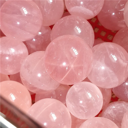 Close-up of rose quartz ball showing natural veins and transparency